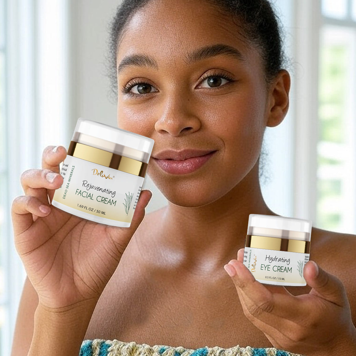 Smiling woman holding a Deluvia Hydrating Eye Cream in one hand and a Deluvia Rejuvenating Facial Cream in the other hand.