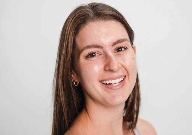 Image of smiling woman with no makeup on with red, sensitive skin