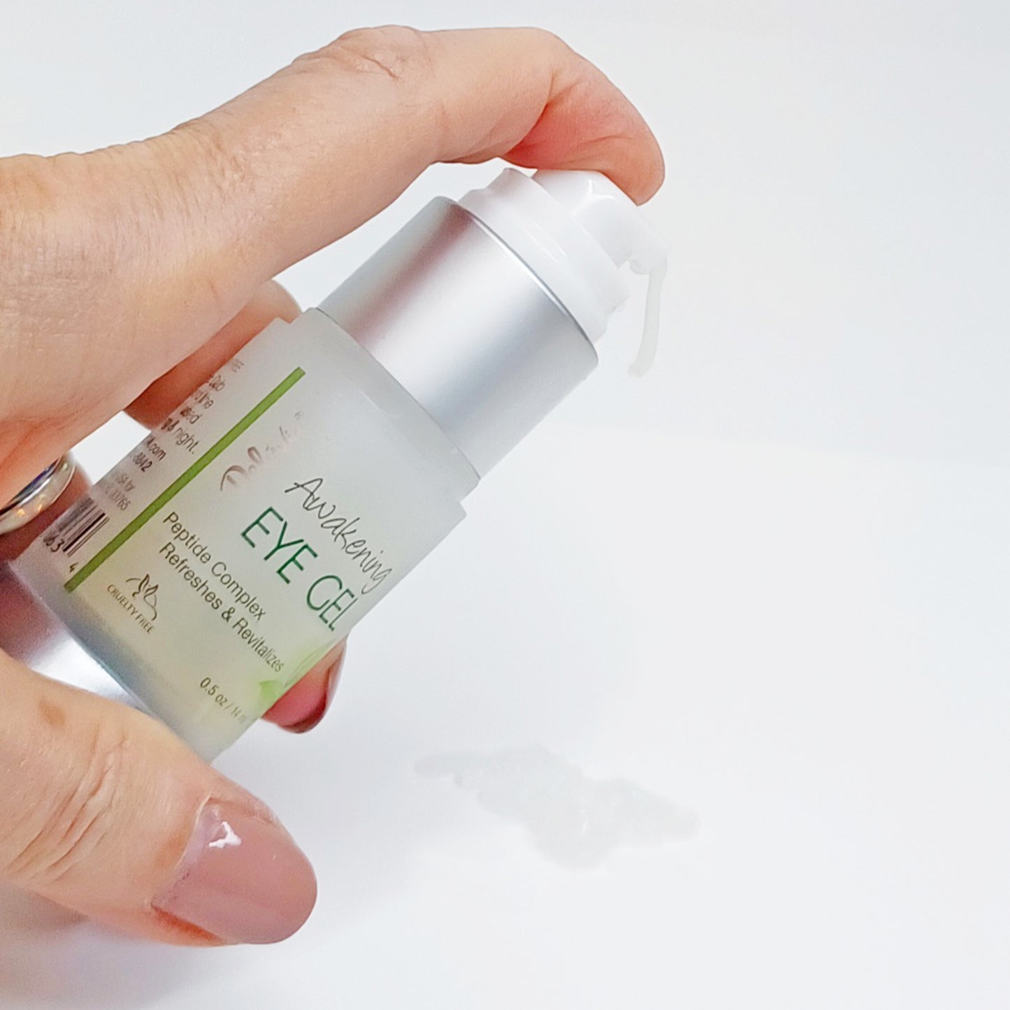 Deluvia Awakening Eye Gel pump with gel dripping out of the bottle to show the texture