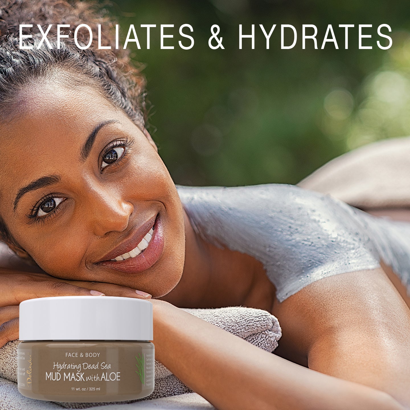 Smiling woman lying down with Deluvia Hydrating Dead Sea Mud Mask with Aloe on her back and shoulders