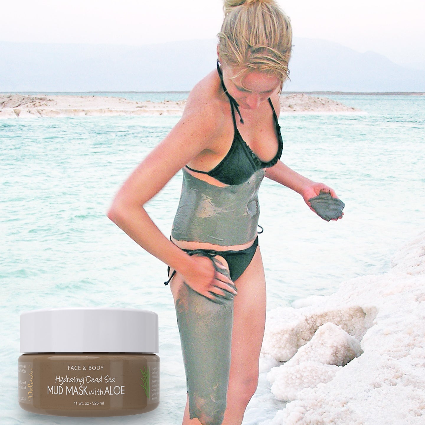 Woman applying Deluvia Hydrating Dead Sea Mud Mask with Aloe to her leg and torso