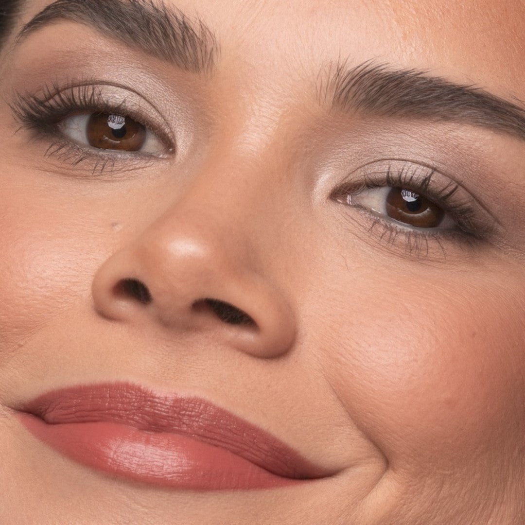 Close-up of a woman's face with Demure Black Mascara on her eyes.