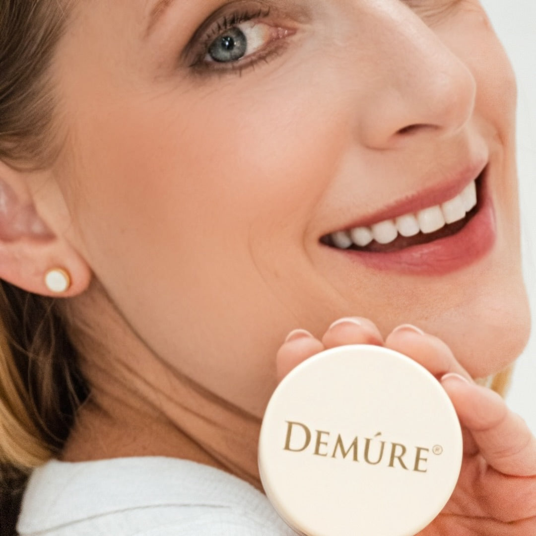Woman wearing Demure Bloom Blush holding the jar on her shoulder