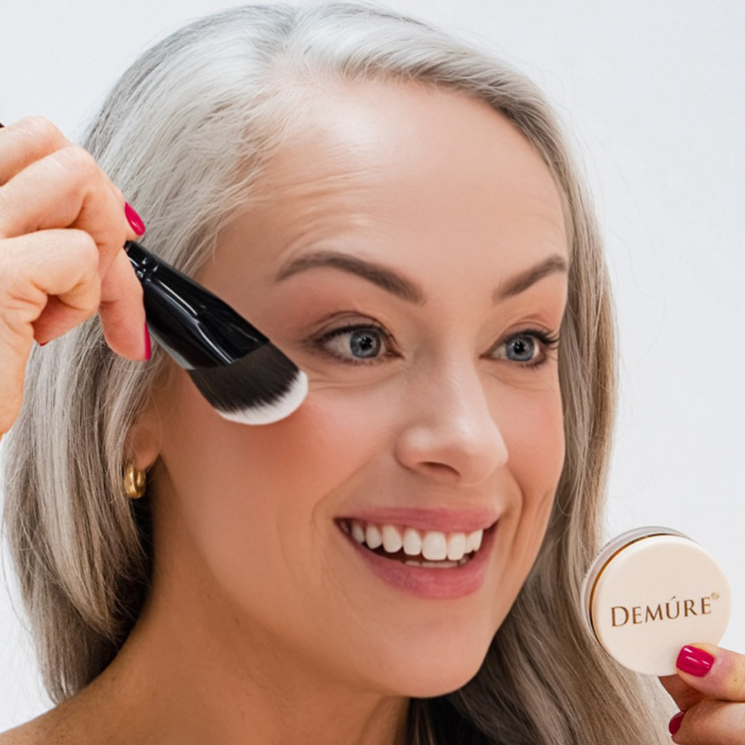 Woman applying Demure Peachy Blush with a contouring brush and jar 