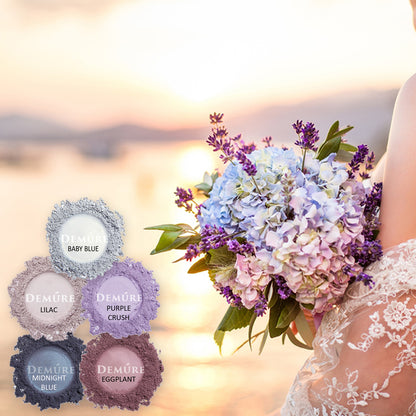 Bouquet of flowers held by a person with color swatches labeled 'Baby Blue', 'Lilac', 'Purple Crush', 'Eggplant', and 'Midnight Blue' against a blurred sunset background.