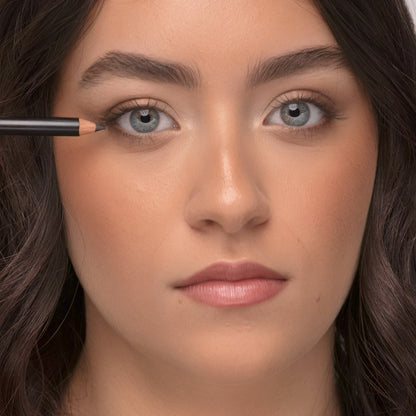 Close-up of a woman applying Demure Earth Eye Liner pencil