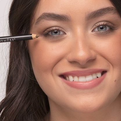 Woman applying Demure Sage Eye Liner pencil on her right eye
