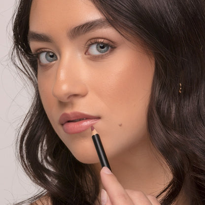 Woman wearing Demure Antique Rose Lip liner with the pencil outlining her lower lip.