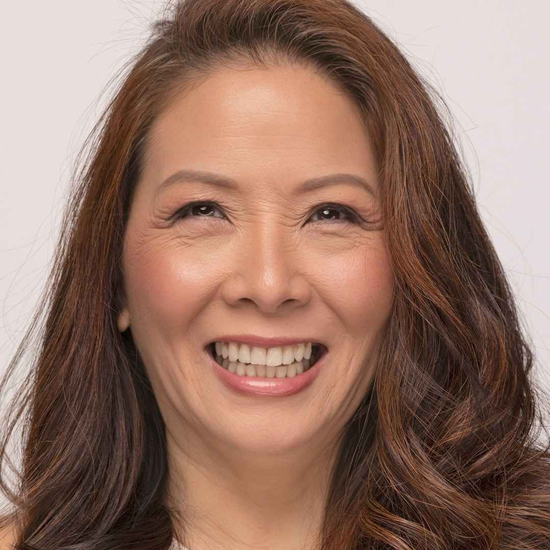 Woman with long brown hair waring Demure Medium Dark Warm Foundation  smiling against a plain background