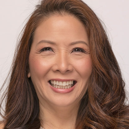 Woman with long brown hair waring Demure Medium Dark Warm Foundation  smiling against a plain background