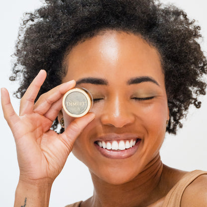 African American woman wearing Moss Eye Color and holding the jar over her left eye