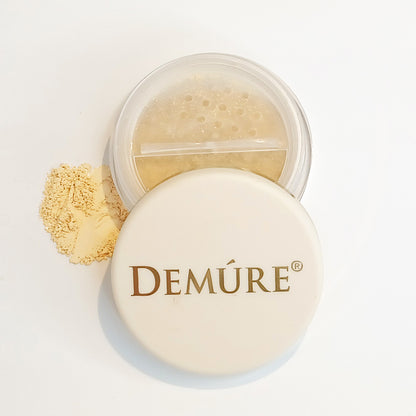 Open container of Demure Original Concealer with a swatch of the minerals on a light background