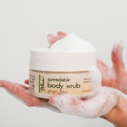 Woman holding Deluvia Ginger Citrus Body Scrub with it sudsing in her hand