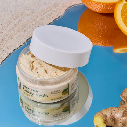Jar of Deluvia Ginger Citrus Body Scrub with the lid partially off