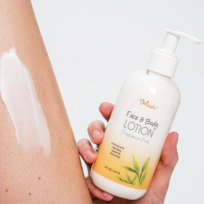 Hand holding a bottle of Deluvia Hand & Body Lotion with lotion applied to skin.