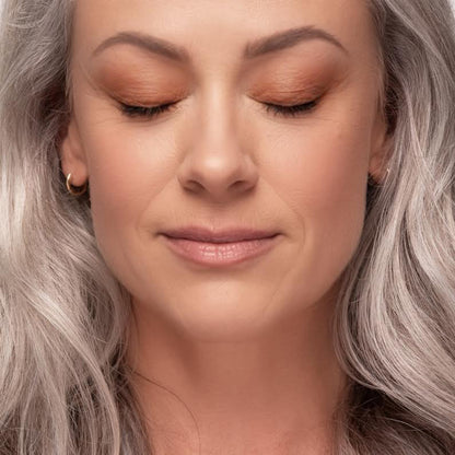 Close-up of a woman with Demure Dusty Rose eyeshadow on and silver hair.