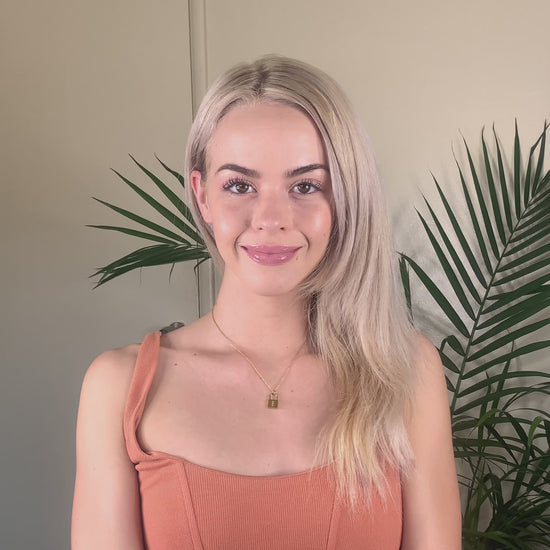 Video clip of a young blonde woman spraying her hair with the Deluvia Beach Hair  Sea Salt Spray product and  waiting a few minutes for the product to dry before her hair is made bouncy again by the product