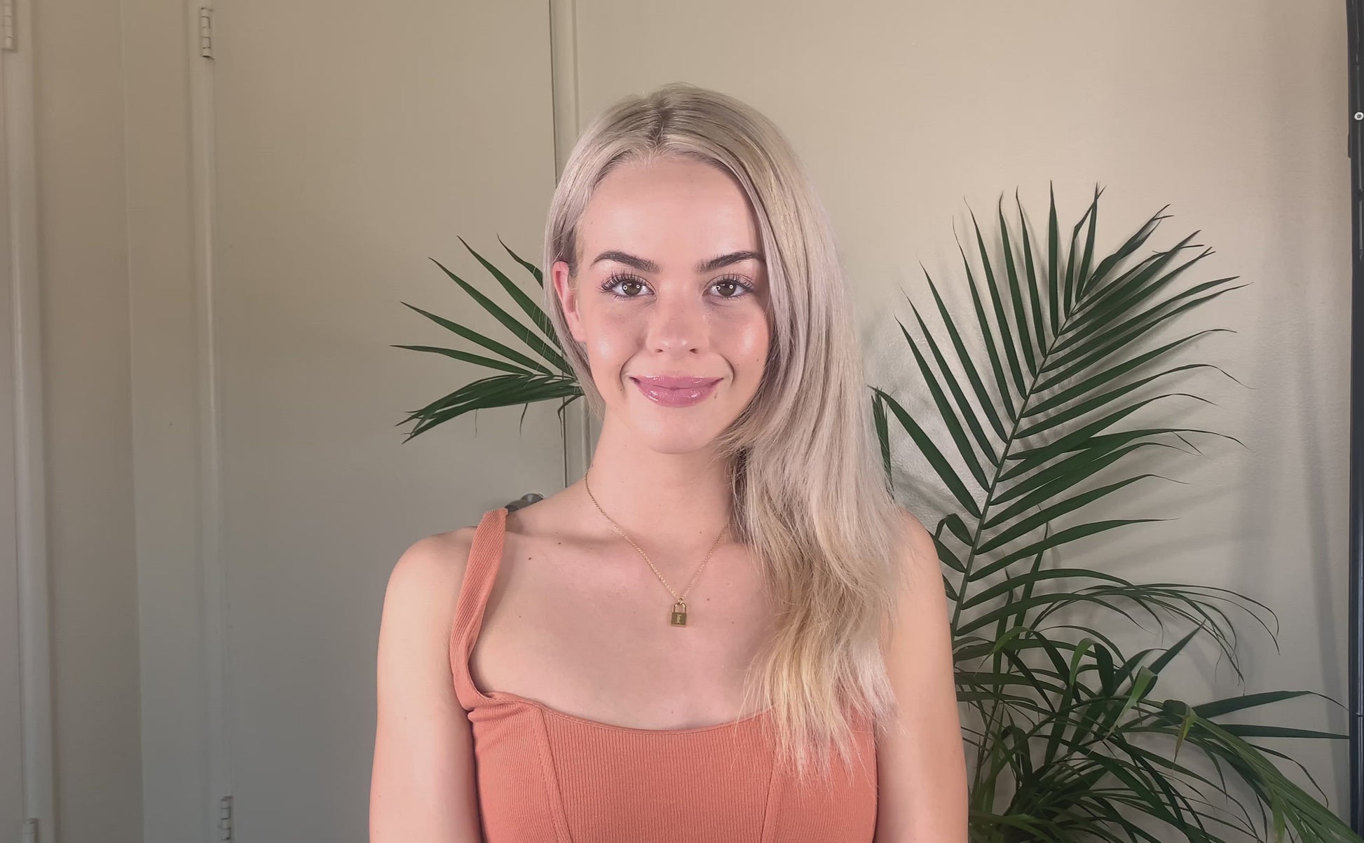 Video clip of a young blonde woman spraying her hair with the Deluvia Beach Hair  Sea Salt Spray product and  waiting a few minutes for the product to dry before her hair is made bouncy again by the product