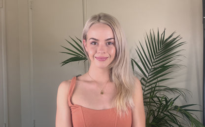 Video clip of a young blonde woman spraying her hair with the Deluvia Beach Hair  Sea Salt Spray product and  waiting a few minutes for the product to dry before her hair is made bouncy again by the product