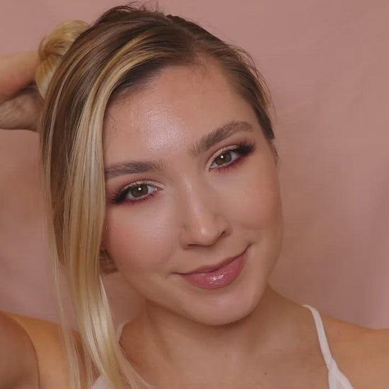 Video clip of a young woman with blonde hair applying the Deluvia Beach Hair Sea Salt Spray product to her hair and feeling happy about it  