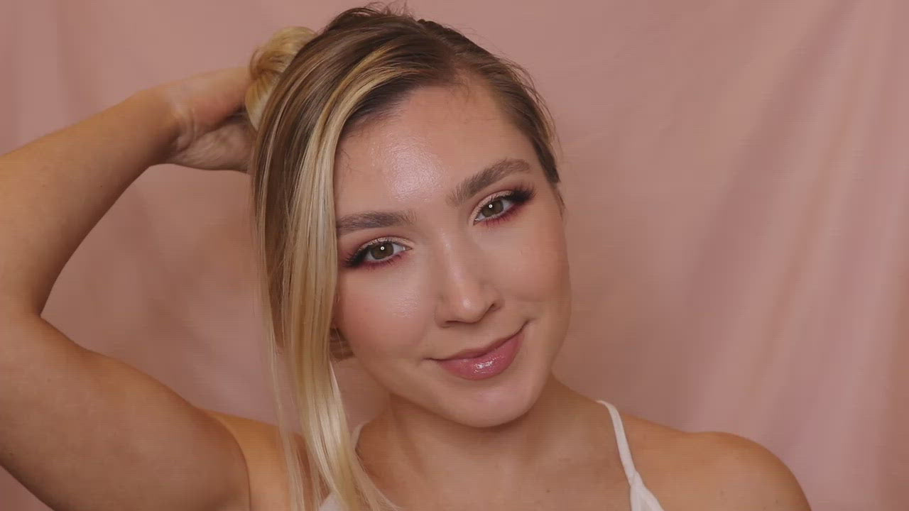 Video clip of a young woman with blonde hair applying the Deluvia Beach Hair Sea Salt Spray product to her hair and feeling happy about it  