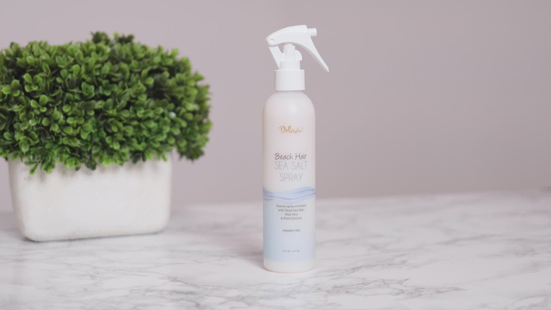 Video clip showing a young brunette spraying her hair with the Deluvia Beach Hair Sea Salt Spray product