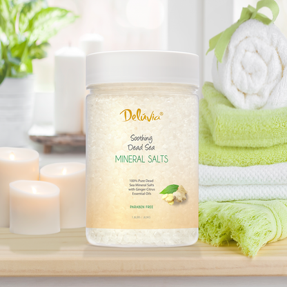 Photocomposition of a 1.8 lbs jar of Deluvia Dead Sea Mineral Salts set on a wood table with candles and towels